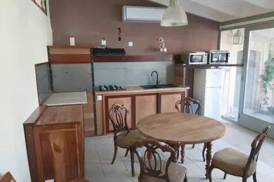 a kitchen with a table and chairs and a sink at Loft atelier dans ancien domaine viticole in Moux