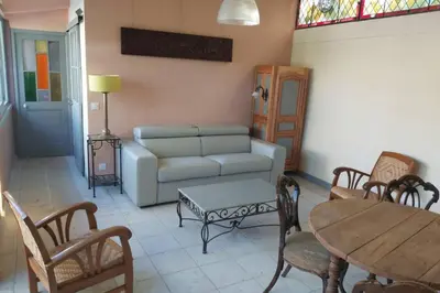 a living room with a couch and a table and chairs at Loft atelier dans ancien domaine viticole in Moux