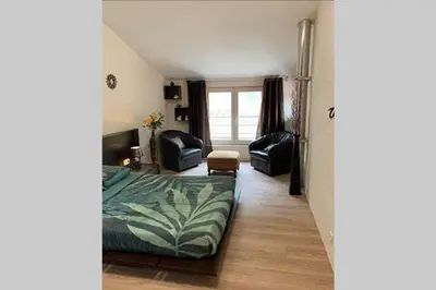a bedroom with a bed and chairs in a room at Havre de paix au pied de la montagne in Les Ilhes