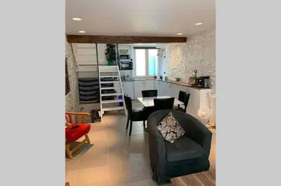 a living room with a table and chairs and a kitchen at Havre de paix au pied de la montagne in Les Ilhes