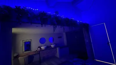 a dark room with a mirror and blue lights at le joyau de la cite in Carcassonne