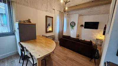 a living room with a wooden table and a couch at le joyau de la cite in Carcassonne
