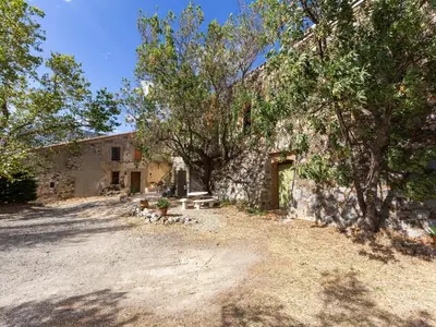 an old stone building with trees in front of it at Charming Holiday Home in Tautavel with Balcony in Tautavel