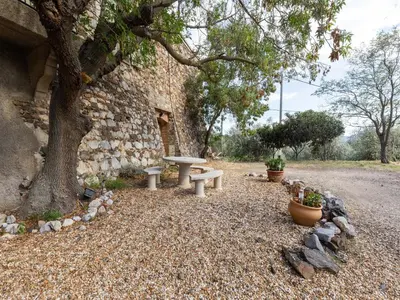 a stone building with a picnic table and a tree at Charming Holiday Home in Tautavel with Balcony in Tautavel