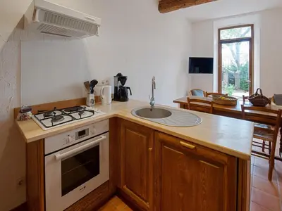 a kitchen with a sink and a stove top oven at Charming Holiday Home in Tautavel with Balcony in Tautavel
