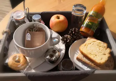 a lunch box with a cup and a plate of food at Suite l'inattendu avec Spa privatif et espace bien-être. in Moussan