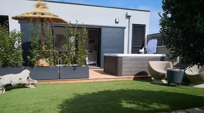 a backyard with a lawn with a tub and toilets at Suite l'inattendu avec Spa privatif et espace bien-être. in Moussan