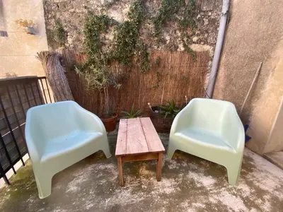 two chairs and a coffee table on a patio at la Porte bleue in Capestang