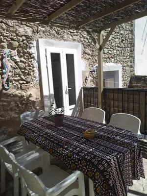 a table with white chairs and a table cloth on a patio at la Porte bleue in Capestang