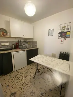 a kitchen with a table in the middle of a room at la Porte bleue in Capestang