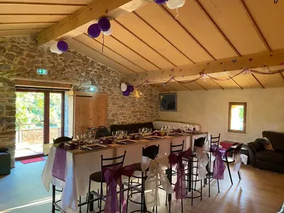 a room with a long table with chairs and purple bows at La Grange du Soleil in Rouvenac