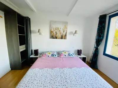 a bedroom with a large bed with a pink blanket at Mas des Tournevents in Lézignan-Corbières