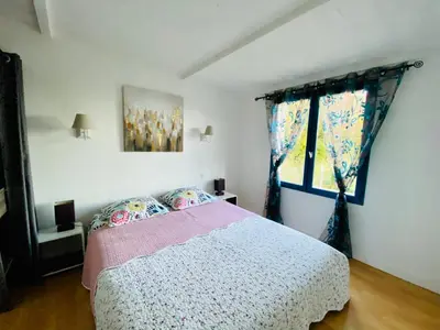 a bedroom with a bed and a window at Mas des Tournevents in Lézignan-Corbières