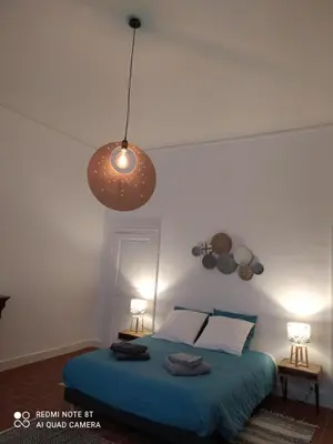 a bedroom with a bed with a blue comforter at Le Selamat, Logis XXL au calme avec Terrasse in Carcassonne