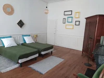 two beds in a room with wooden floors at Le Selamat, Logis XXL au calme avec Terrasse in Carcassonne