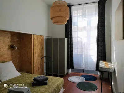 a small bedroom with a bed and a window at Le Selamat, Logis XXL au calme avec Terrasse in Carcassonne