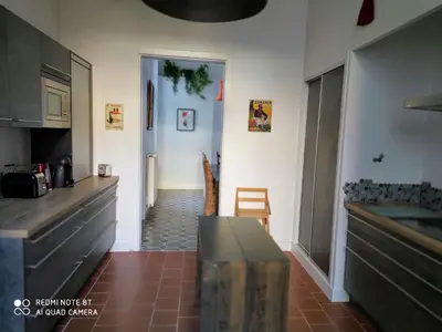 a kitchen with a counter and a table in it at Le Selamat, Logis XXL au calme avec Terrasse in Carcassonne