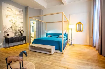 a bedroom with a blue bed and a horse statue at Le Belem in Carcassonne