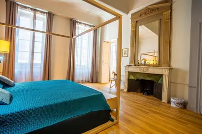 a bedroom with a bed and a mirror and a fireplace at Le Belem in Carcassonne