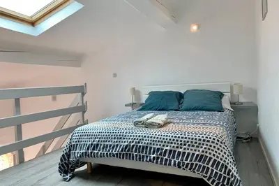 a bedroom with a bed with blue pillows at Duplex Carcassonne centre in Carcassonne