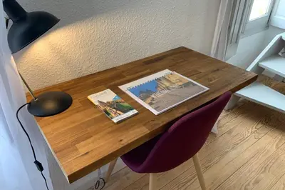 a wooden table with two magazines and a lamp on it at Duplex Carcassonne centre in Carcassonne