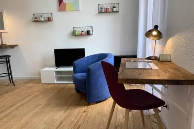 a living room with a table and a blue chair at Duplex Carcassonne centre in Carcassonne