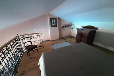 a bedroom with a bed and a staircase with a blue light at Cave atelier dans ancien domaine viticole in Moux