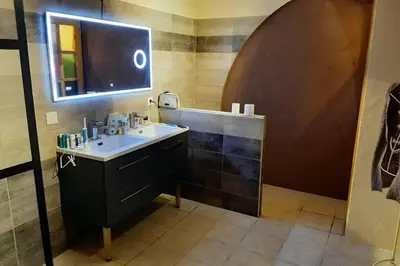 a bathroom with a sink and a mirror at Cave atelier dans ancien domaine viticole in Moux