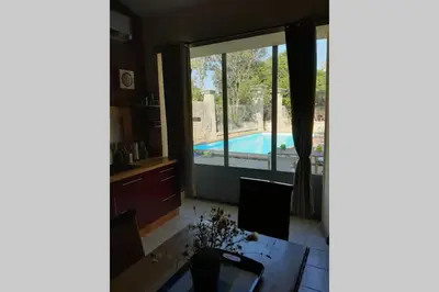 a kitchen with a view of a swimming pool through a sliding glass door at Cave atelier dans ancien domaine viticole in Moux