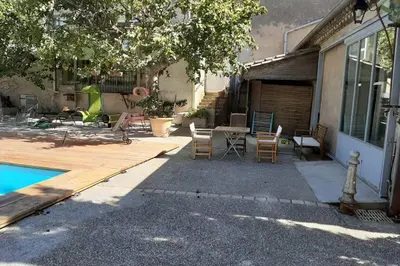 a patio with a table and chairs next to a house at Cave atelier dans ancien domaine viticole in Moux