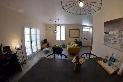 a living room with a dining table and a living room at MAISON DIANA in Capestang