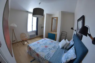 a bedroom with a bed and a blue couch at MAISON DIANA in Capestang
