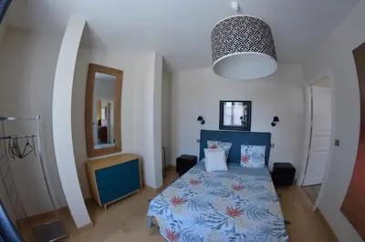 a bedroom with a blue bed and a mirror at MAISON DIANA in Capestang