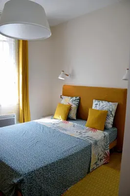 a bedroom with a blue bed with yellow pillows at MAISON DIANA in Capestang