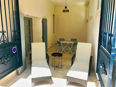 a room with white chairs and a table and a table and chairs at MAISON DIANA in Capestang