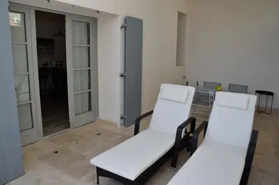 two white chairs in a room with a kitchen at MAISON DIANA in Capestang