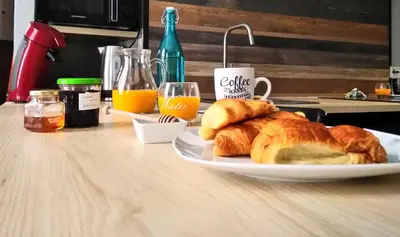 a plate of croissants and orange juice on a table at Le tout cosy - Wifi - Disney - EvasionPamiers in Pamiers