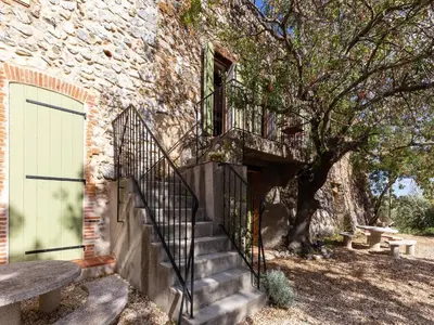 a staircase leading to a building with a door and a tree at Holiday Home in Tautavel near Gorges de Gouleyrous in Tautavel