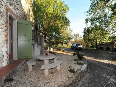 a picnic table in front of a building with a car at Holiday Home in Tautavel near Gorges de Gouleyrous in Tautavel