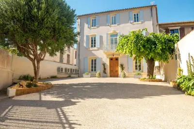 a large white house with trees in the driveway at La Maison des Vendangeurs en Ville in Narbonne
