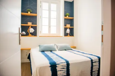 a bedroom with a bed and a window and shelves at La Maison des Vendangeurs en Ville in Narbonne