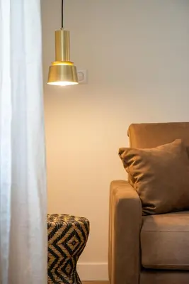 a living room with a couch and a lamp at La Maison des Vendangeurs en Ville in Narbonne