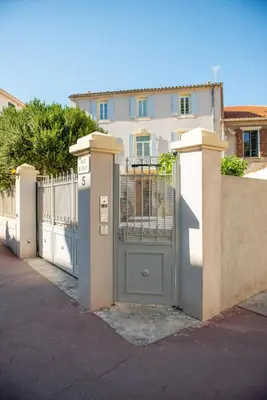 a gate in front of a white building at La Maison des Vendangeurs en Ville in Narbonne