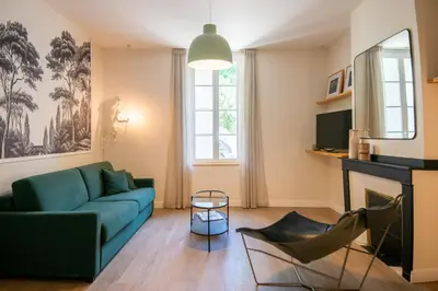 a living room with a blue couch and a fireplace at La Maison des Vendangeurs en Ville in Narbonne