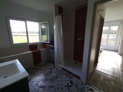 a bathroom with a sink and a table with a chair at Le pigeonnier de La Mouline in Viterbe
