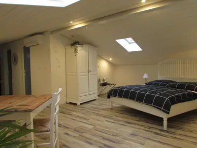 a bedroom with a bed and a table in it at Le Parc - Suite climatisée in Magrie