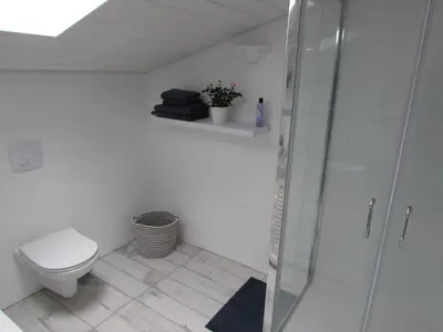 a bathroom with a toilet and a glass shower at Le Parc - Suite climatisée in Magrie