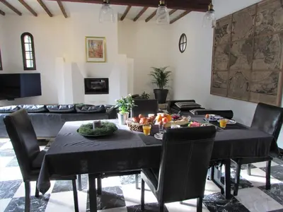 a dining room with a black table and chairs at Le Parc - Suite climatisée in Magrie