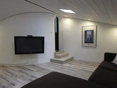 a living room with a flat screen tv on a wall at Le Parc - Suite climatisée in Magrie