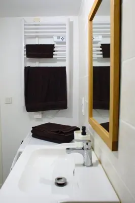 a bathroom with a sink and a mirror and towels at T3 cosy au centre de Castelnaudary in Castelnaudary